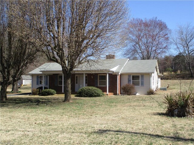 single story home with a chimney and a front lawn