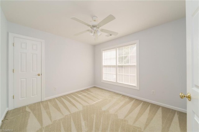 unfurnished bedroom featuring ceiling fan, light colored carpet, and a closet