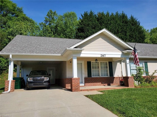267 S Boyles St, Pilot Mountain, NC 27041 - view of front of house with brick siding, driveway, covered porch, a shingled roof, and a front lawn