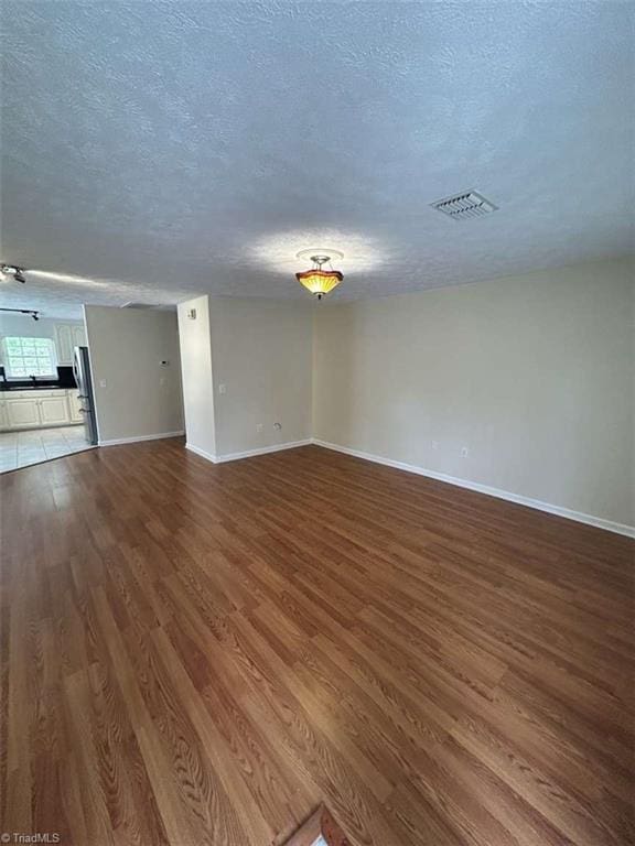 267 S Boyles St, Pilot Mountain, NC 27041 - unfurnished room with dark wood-style floors, a textured ceiling, and baseboards