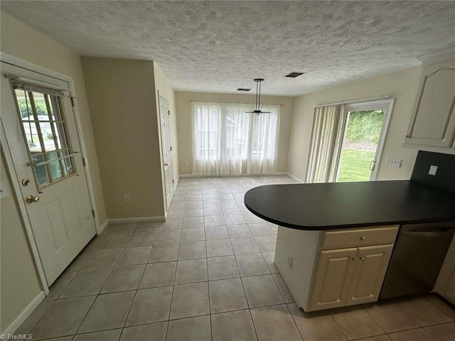 267 S Boyles St, Pilot Mountain, NC 27041 - kitchen with light tile patterned floors, baseboards, dishwasher, dark countertops, and a peninsula