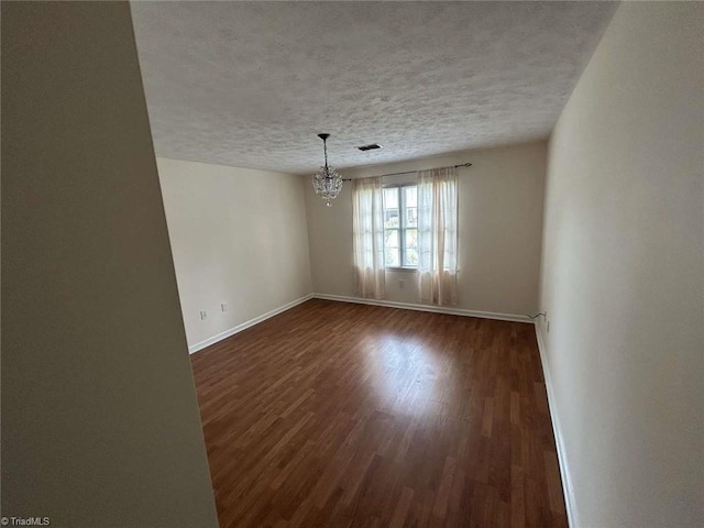 267 S Boyles St, Pilot Mountain, NC 27041 - unfurnished dining area featuring dark wood finished floors, a textured ceiling, baseboards, and a chandelier