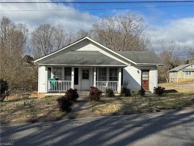 bungalow-style home featuring roof with shingles and a porch