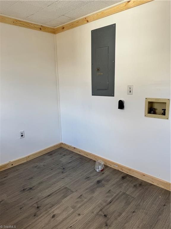 unfurnished room featuring electric panel, baseboards, and wood finished floors