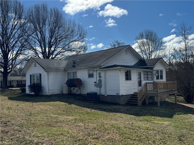 rear view of property with a wooden deck, a yard, and roof with shingles