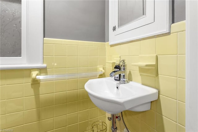 bathroom featuring a sink and tile walls