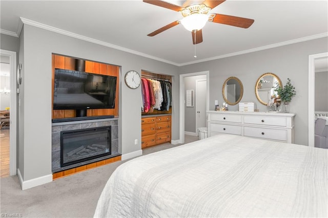 carpeted bedroom featuring crown molding, a fireplace, baseboards, and a ceiling fan