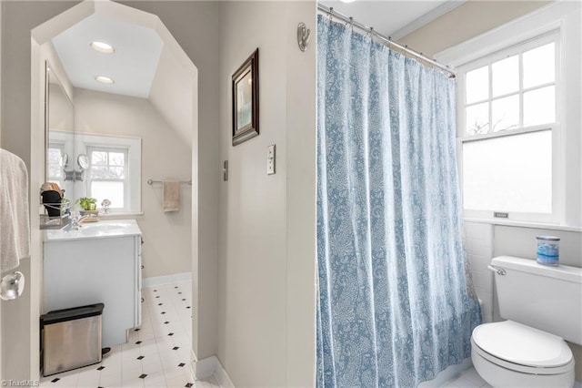 bathroom featuring toilet, curtained shower, vanity, and baseboards