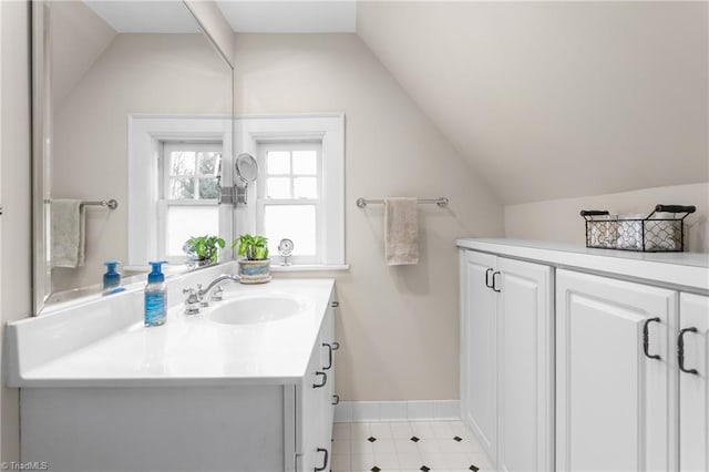 bathroom featuring lofted ceiling, baseboards, and vanity