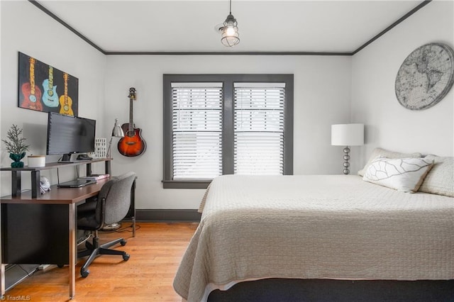 bedroom featuring crown molding, baseboards, and wood finished floors