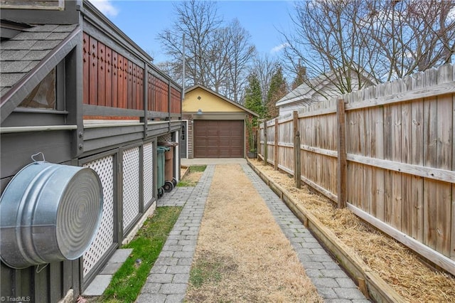 view of yard with an outbuilding, driveway, fence, and a garage