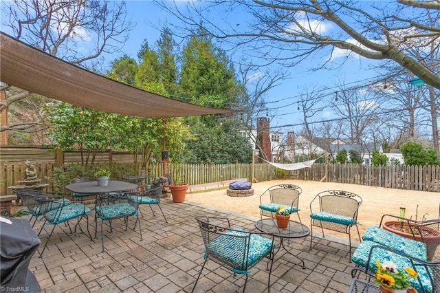 view of patio featuring an outdoor fire pit, grilling area, outdoor dining space, and a fenced backyard