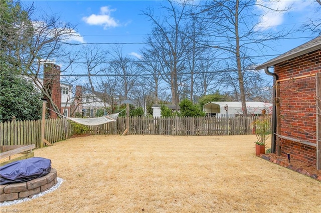 view of yard featuring an outdoor fire pit and fence