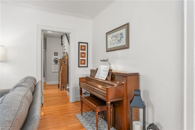 corridor with light wood-style floors, baseboards, and ornamental molding