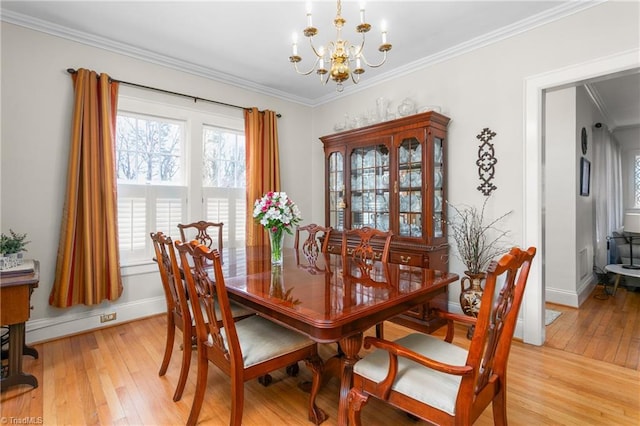 dining space featuring a notable chandelier, crown molding, and light wood-style floors