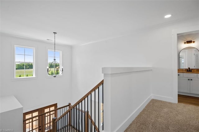 hall featuring an inviting chandelier and carpet