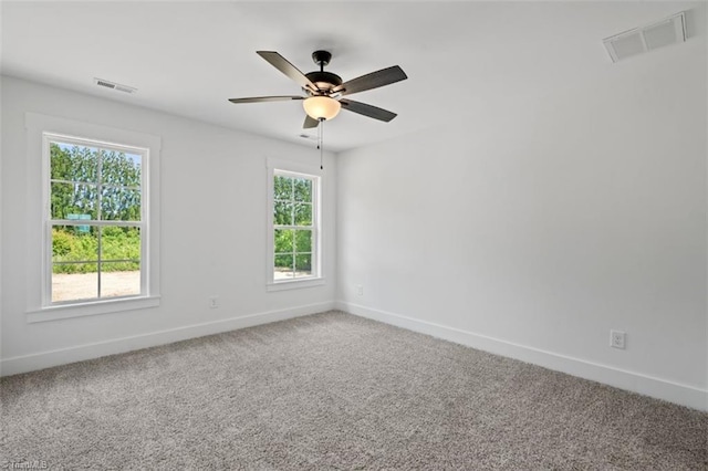 carpeted spare room featuring ceiling fan