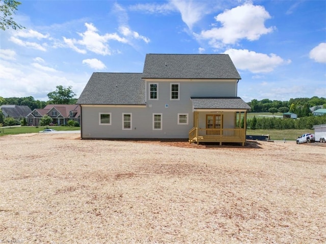 rear view of property featuring covered porch