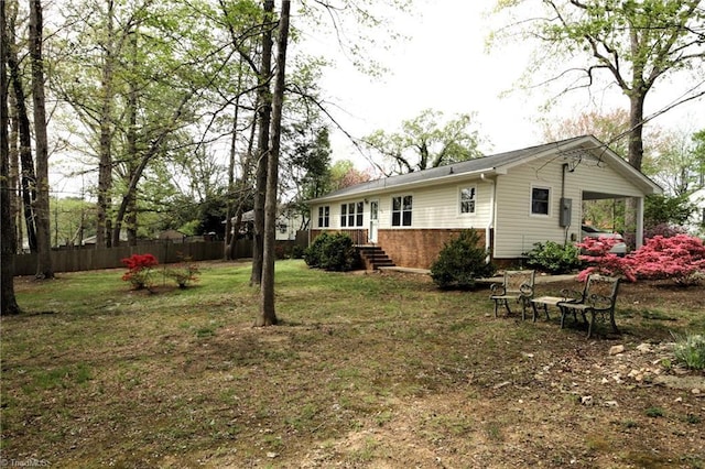 back of house featuring a yard and fence