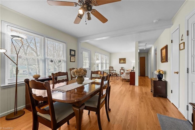 dining area featuring light wood-style floors, baseboards, and a ceiling fan