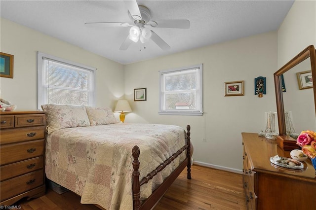 bedroom featuring dark wood-style flooring, baseboards, and a ceiling fan