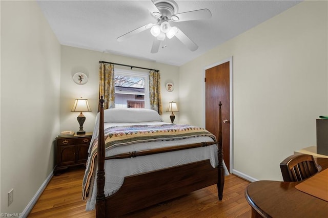 bedroom with baseboards, a ceiling fan, and wood finished floors