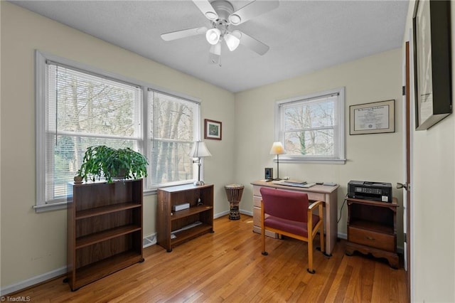 office featuring light wood-type flooring, baseboards, and a ceiling fan