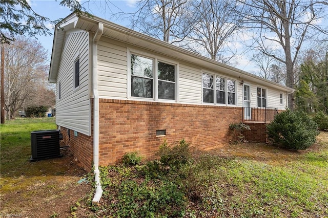 view of property exterior featuring cooling unit, a yard, crawl space, and brick siding