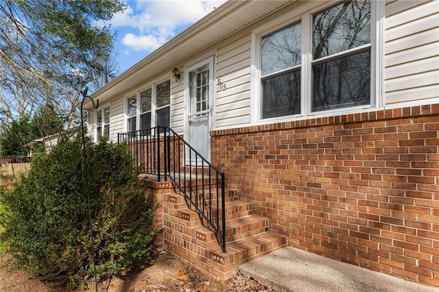 entrance to property featuring brick siding