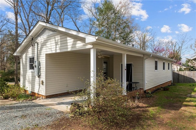 view of front of property with a carport, driveway, crawl space, a ceiling fan, and fence