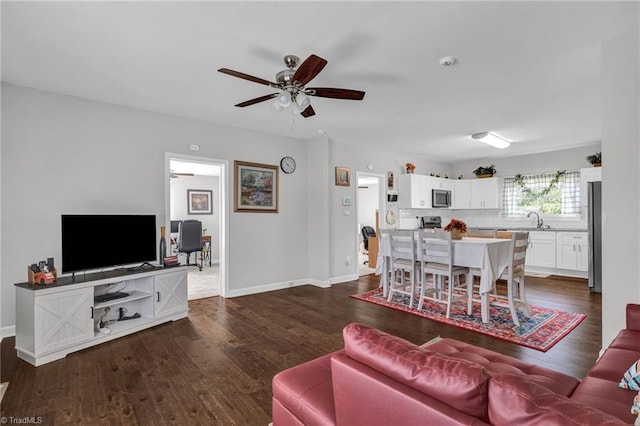 living room with dark hardwood / wood-style floors, ceiling fan, and sink