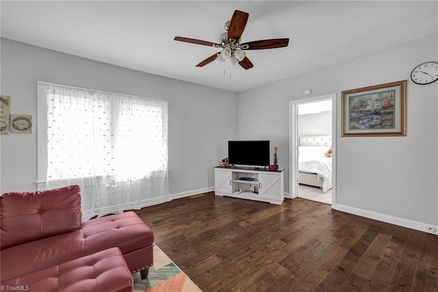 living room with ceiling fan and dark wood-type flooring