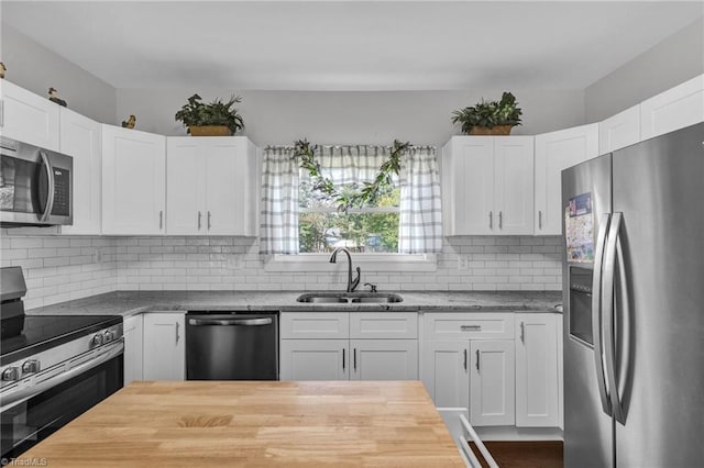 kitchen with white cabinets, appliances with stainless steel finishes, backsplash, and sink