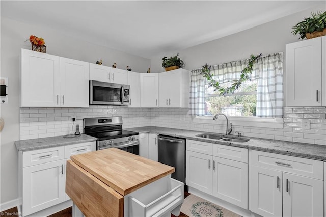 kitchen with white cabinets, appliances with stainless steel finishes, tasteful backsplash, and sink