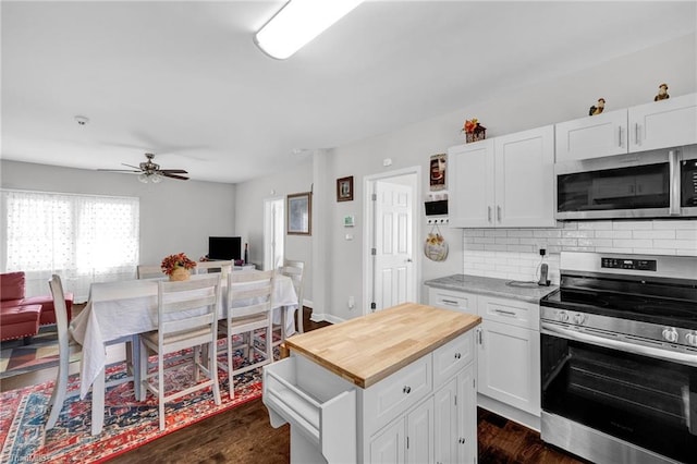 kitchen with white cabinetry, backsplash, dark hardwood / wood-style flooring, stainless steel appliances, and ceiling fan