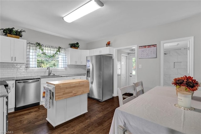 kitchen featuring a healthy amount of sunlight, white cabinets, appliances with stainless steel finishes, and a kitchen island