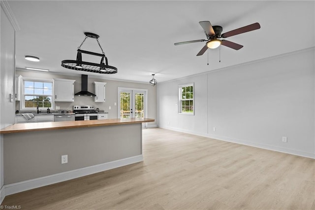 2505 Banner Whitehead Rd, Sophia, NC 27350 - kitchen featuring butcher block countertops, stainless steel appliances, light wood-style floors, wall chimney range hood, and white cabinets