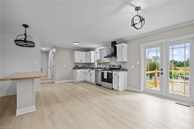 kitchen with wall chimney range hood, white cabinets, hanging light fixtures, butcher block counters, and stainless steel appliances