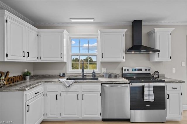 kitchen featuring wall chimney range hood, white cabinets, sink, crown molding, and stainless steel appliances