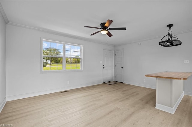 spare room featuring crown molding, light hardwood / wood-style flooring, and ceiling fan