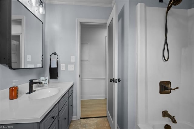 bathroom featuring vanity, crown molding, and bathtub / shower combination