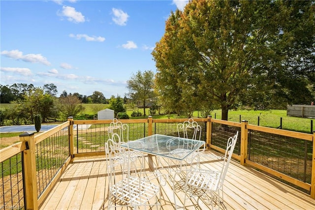 wooden terrace with a shed and a lawn