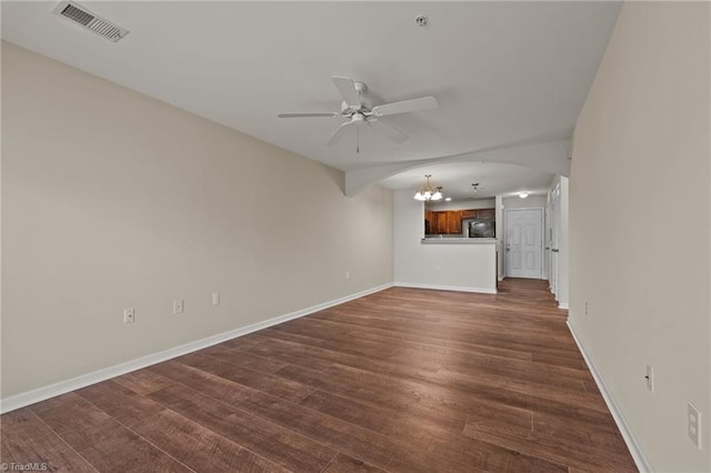 unfurnished living room featuring dark hardwood / wood-style flooring and ceiling fan with notable chandelier