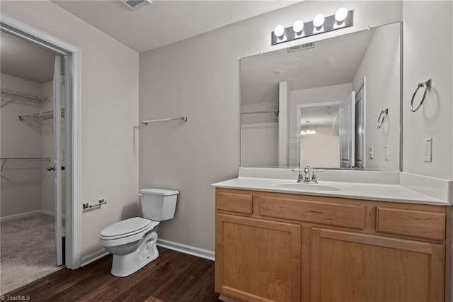 bathroom featuring vanity, wood-type flooring, and toilet