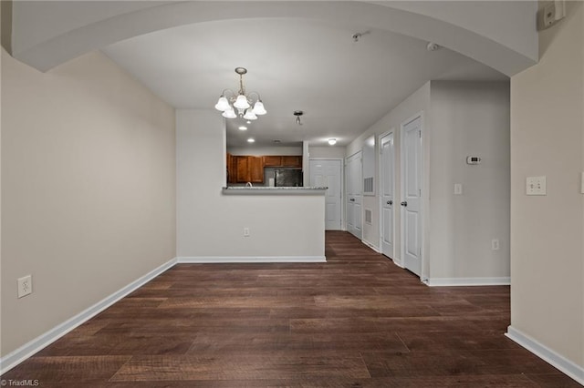 interior space with a chandelier and dark hardwood / wood-style flooring