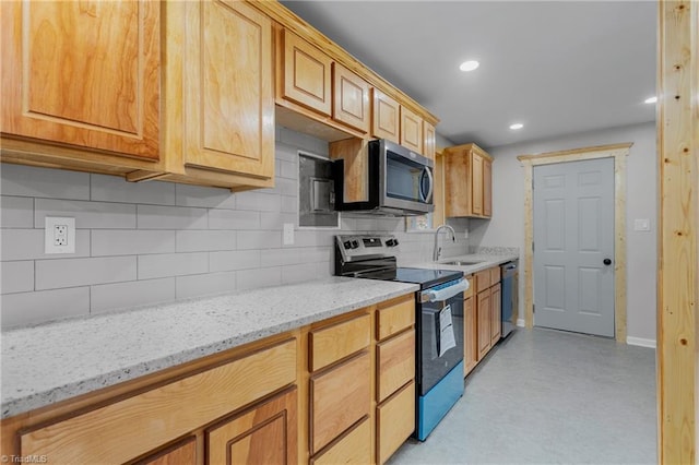 kitchen featuring appliances with stainless steel finishes, light stone countertops, sink, and decorative backsplash