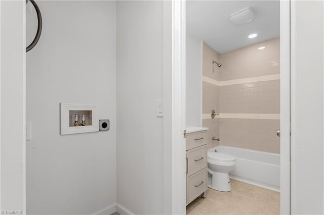 full bathroom featuring tiled shower / bath, vanity, and toilet