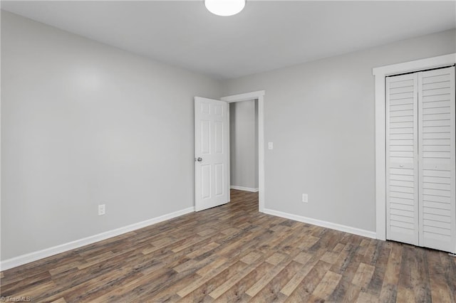 unfurnished bedroom with dark hardwood / wood-style floors and a closet