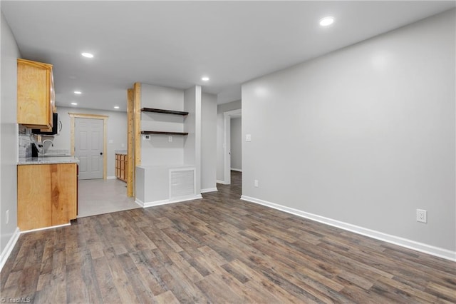 unfurnished living room featuring dark hardwood / wood-style floors and sink