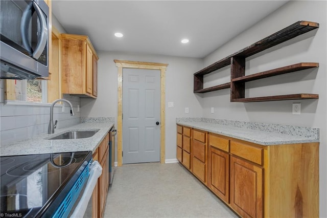 kitchen with light stone counters, sink, and stainless steel appliances